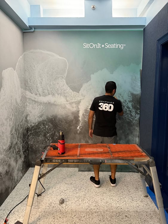 Wall graphic being installed in a elevator hallway