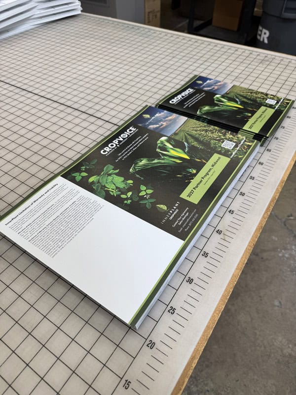 Printed brochures on a table waiting for scoring and folding