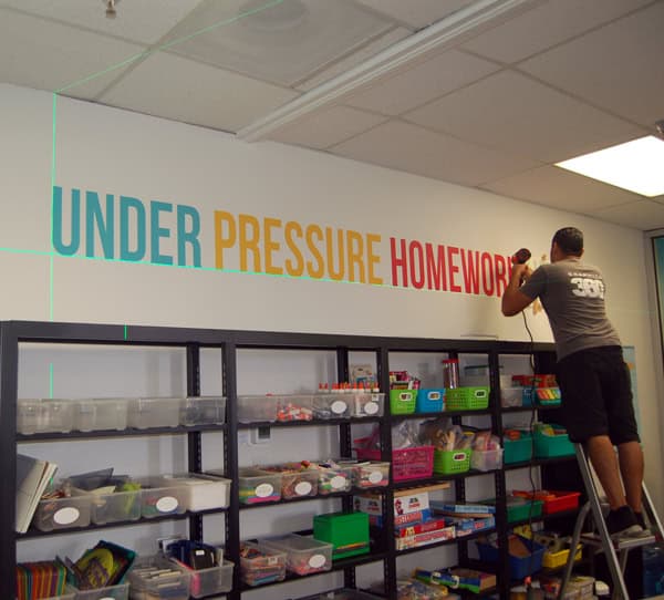 someone installing printed letters on a wall